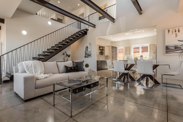 living room featuring concrete floors and a high ceiling