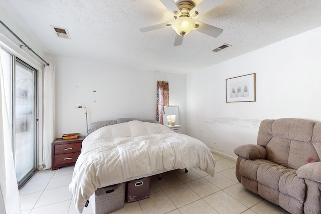 bedroom with light tile patterned floors, a textured ceiling, and ceiling fan