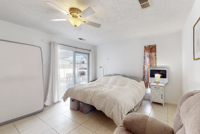 tiled bedroom with access to exterior, a textured ceiling, and ceiling fan