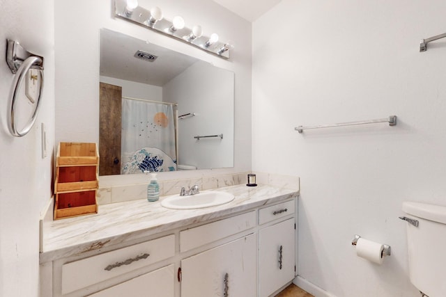 bathroom with vanity, curtained shower, and toilet