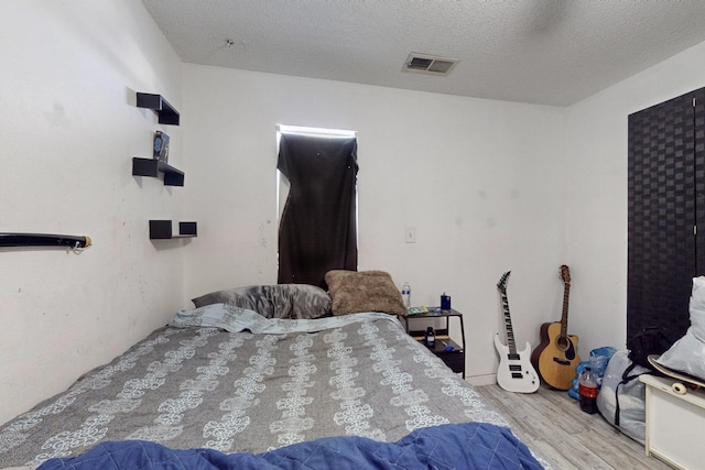 bedroom featuring a textured ceiling and light wood-type flooring