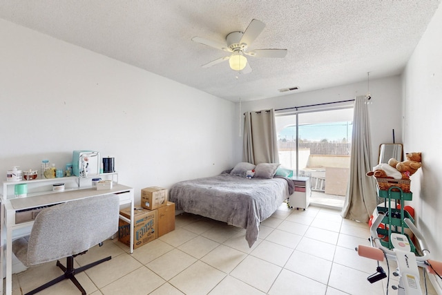 tiled bedroom featuring ceiling fan and a textured ceiling