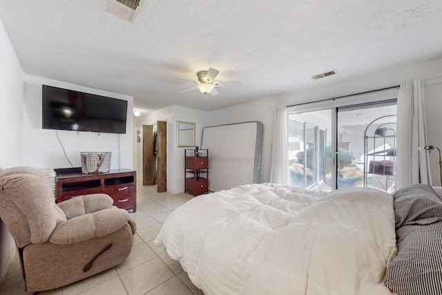 tiled bedroom with ceiling fan, access to exterior, and a textured ceiling