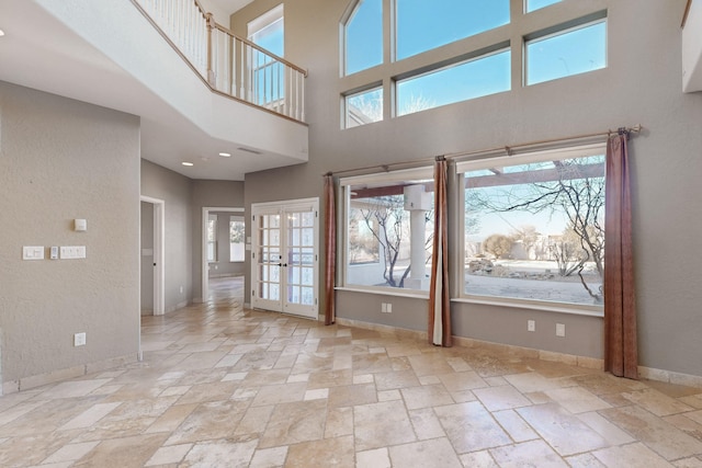 interior space with a towering ceiling and french doors