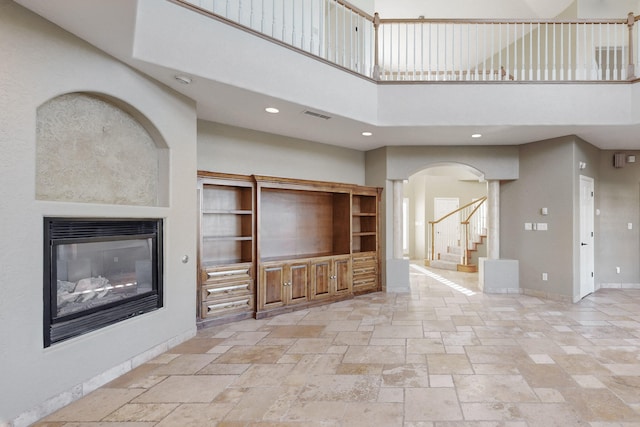 unfurnished living room with a towering ceiling