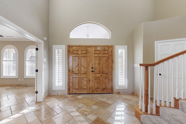 entrance foyer featuring crown molding and a towering ceiling