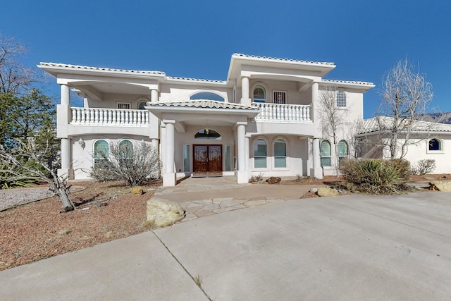 mediterranean / spanish home with french doors and a balcony