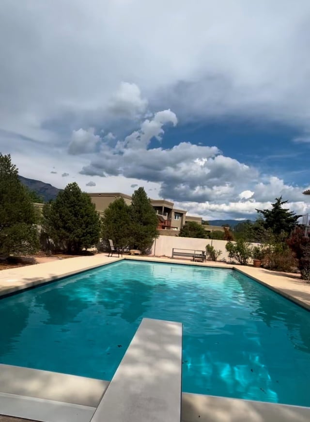 view of swimming pool featuring a diving board