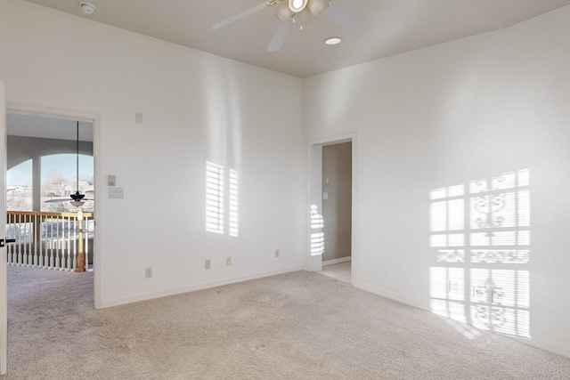 empty room featuring light carpet, plenty of natural light, and ceiling fan