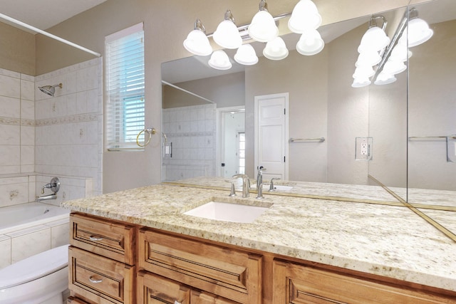 full bathroom with tiled shower / bath, vanity, and toilet