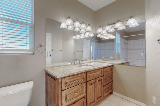 bathroom with toilet, tile patterned floors, vanity, and tiled shower