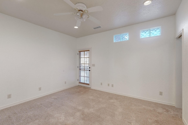 carpeted empty room featuring a textured ceiling and ceiling fan