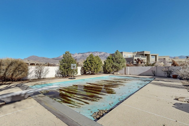 view of pool with a mountain view, a patio area, and a diving board