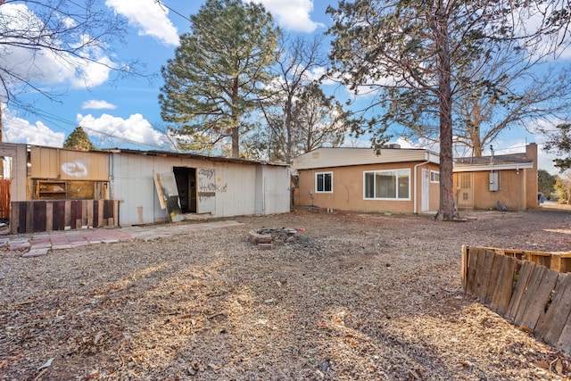 rear view of property featuring a fire pit