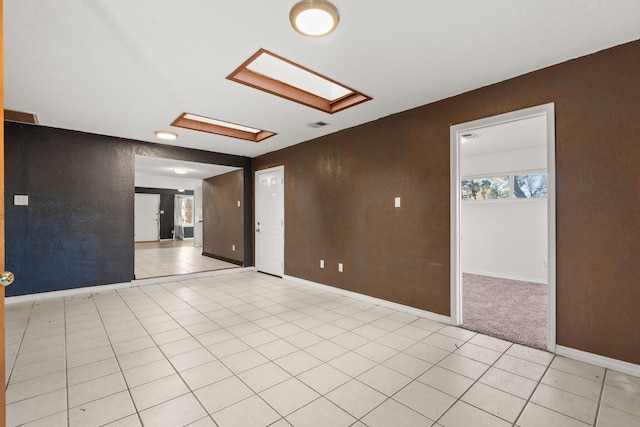 tiled spare room featuring a skylight