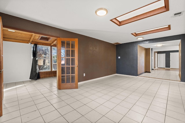 tiled spare room with a skylight