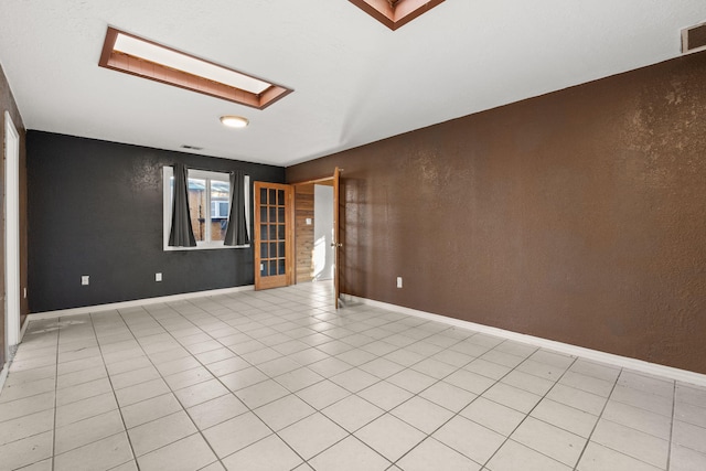 tiled empty room with a skylight