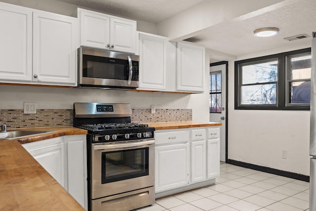 kitchen featuring wood counters, white cabinetry, and appliances with stainless steel finishes