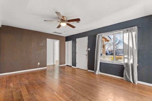 empty room featuring ceiling fan and hardwood / wood-style floors