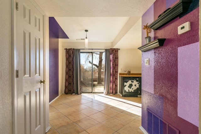 interior space with light tile patterned floors and a textured ceiling