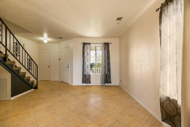 tiled foyer entrance with a textured ceiling