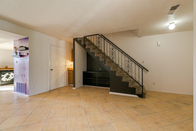 interior space with tile patterned floors and a textured ceiling