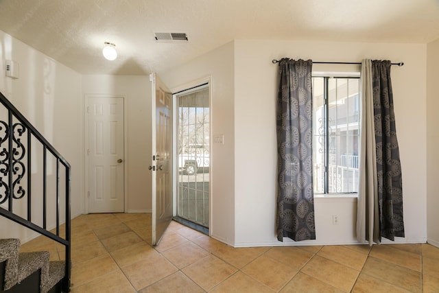 foyer with plenty of natural light and light tile patterned floors