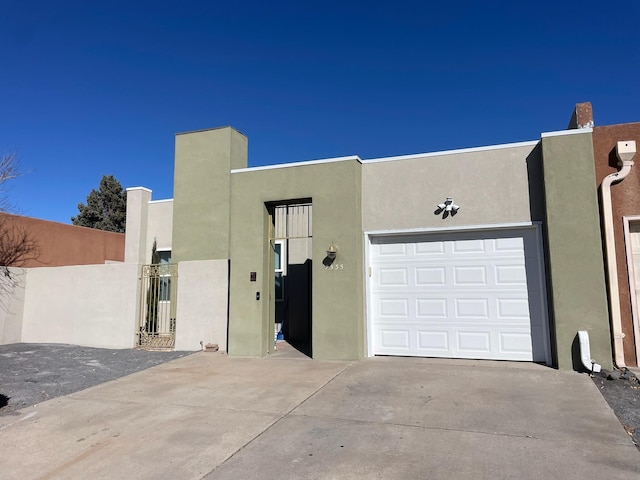 view of front of property with concrete driveway, an attached garage, and stucco siding