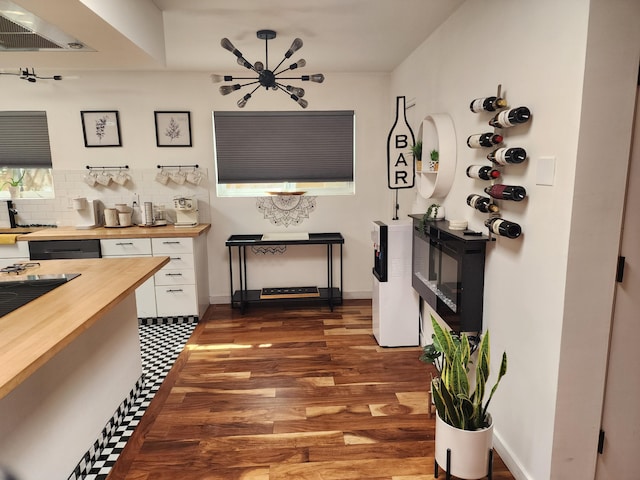 7535 Quemado Ct NE, Albuquerque, NM 87109 - interior space with butcher block countertops, white cabinetry, range hood, decorative backsplash, and dark wood finished floors