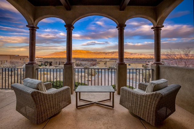 balcony at dusk featuring a mountain view