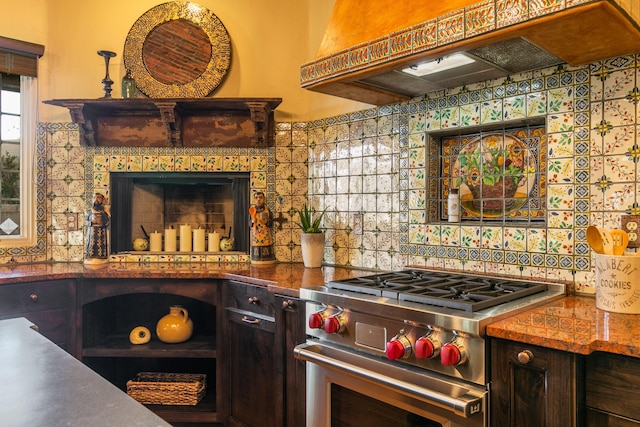 kitchen with dark brown cabinetry, high end range, custom exhaust hood, and backsplash