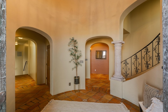 hall featuring a high ceiling and tile patterned floors