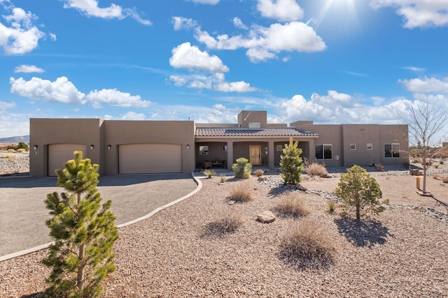 pueblo-style house featuring a garage