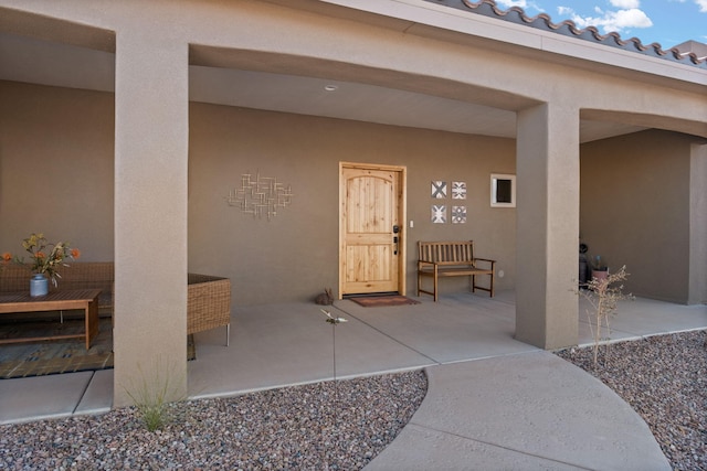 view of exterior entry featuring a patio area