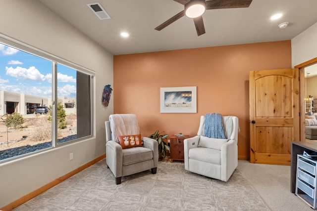 sitting room featuring plenty of natural light, light colored carpet, and ceiling fan