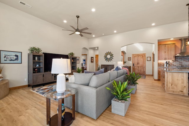 living room with light hardwood / wood-style flooring and ceiling fan