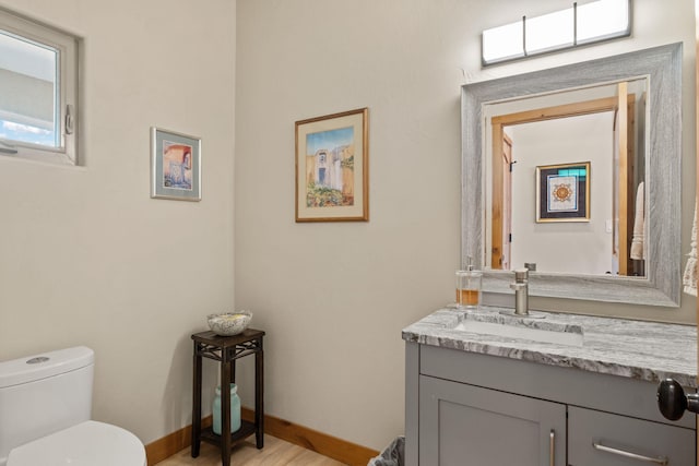 bathroom featuring vanity, hardwood / wood-style flooring, and toilet