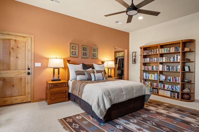 bedroom featuring ceiling fan, a spacious closet, and carpet