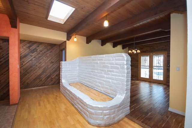 interior space with wood walls, wooden ceiling, wood finished floors, and beam ceiling