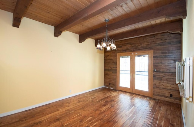 empty room with wood ceiling, wood finished floors, a notable chandelier, and french doors