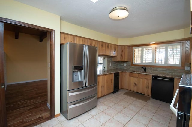 kitchen with a sink, stainless steel fridge with ice dispenser, black dishwasher, backsplash, and brown cabinets