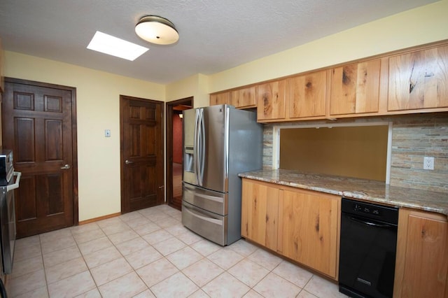 kitchen with light tile patterned floors, decorative backsplash, light stone countertops, stainless steel fridge, and baseboards