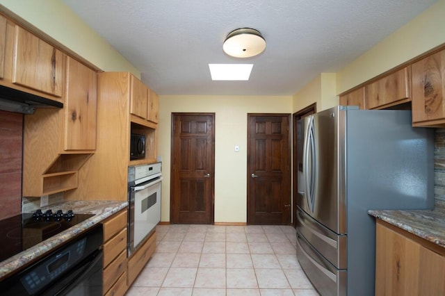 kitchen featuring black microwave, wall oven, oven, stainless steel fridge with ice dispenser, and light stone countertops