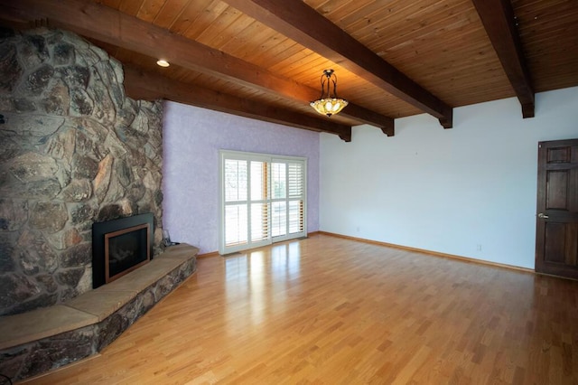 unfurnished living room with light wood-type flooring, wooden ceiling, and a fireplace