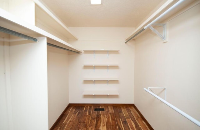 walk in closet featuring dark wood-style flooring