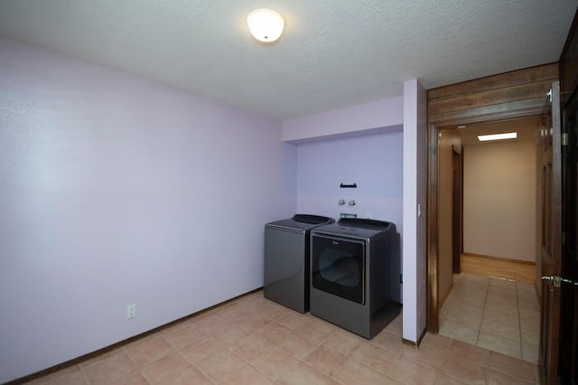 washroom featuring a textured ceiling, laundry area, and washing machine and clothes dryer