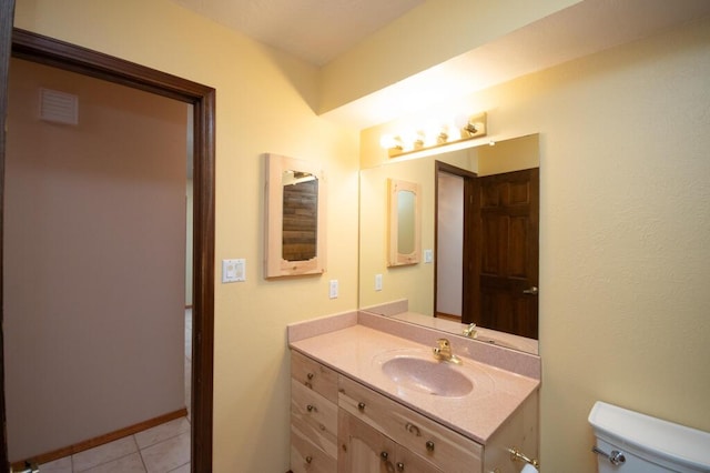 half bathroom featuring toilet, tile patterned floors, visible vents, and vanity