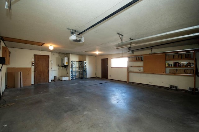 garage featuring a garage door opener, water heater, and visible vents