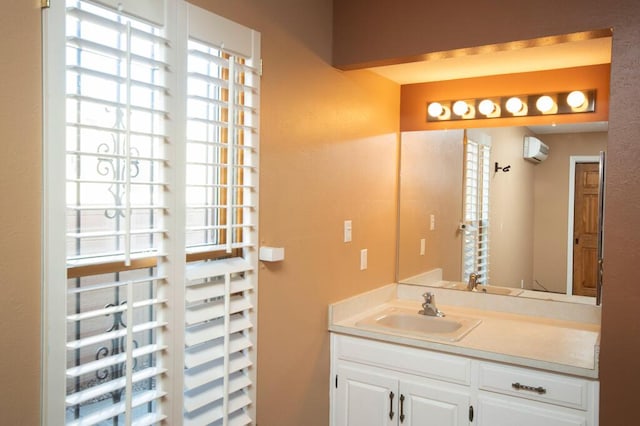 bathroom featuring a wall unit AC and vanity