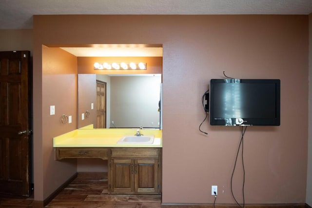 bathroom with baseboards, wood finished floors, and vanity